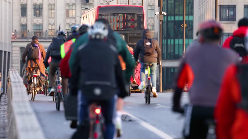Shallow focus view of commuters and workers going into the City of London during morning rush hour with their bicycles