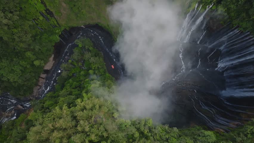 Aerial view of majestic Tumpak Sewu waterfalls in slow motion, Java, Indonesia