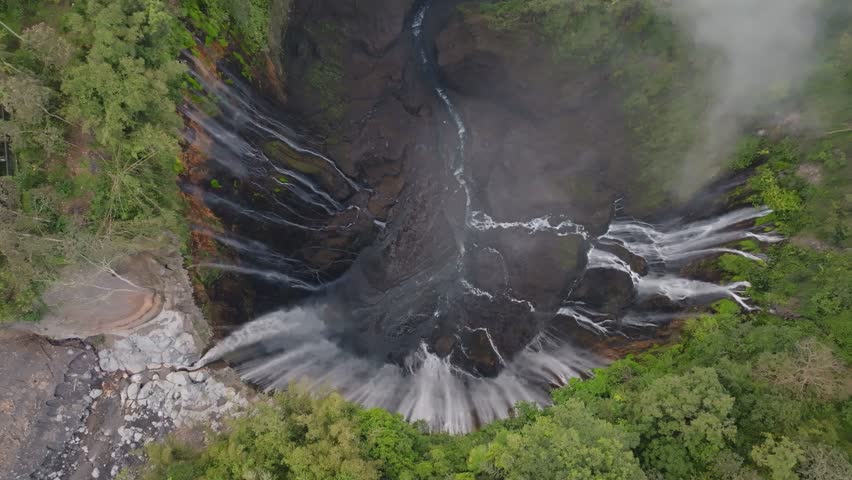 Aerial view of majestic Tumpak Sewu waterfalls in slow motion, Java, Indonesia