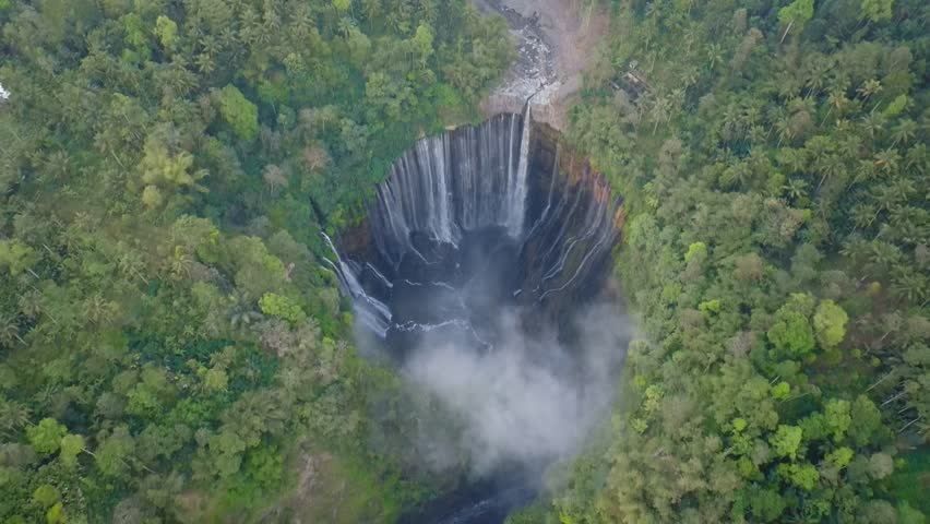 Aerial view of majestic Tumpak Sewu waterfalls in slow motion, Java, Indonesia