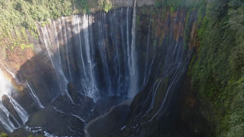 Aerial view of majestic Tumpak Sewu waterfalls in slow motion, Java, Indonesia