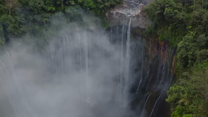 Aerial view of majestic Tumpak Sewu waterfalls in slow motion, Java, Indonesia