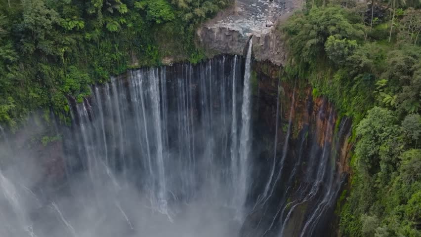 Aerial view of majestic Tumpak Sewu waterfalls in slow motion, Java, Indonesia