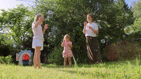 A mother and her two daughters blow soap bubbles together in a sunny backyard, while their playful dog runs around, creating a joyful and carefree family moment surrounded by greenery - Powered by Shutterstock - Get 15% off with code: PIKWIZARD15