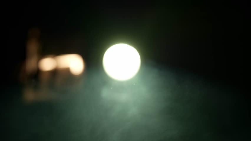 Smoke and dust moving the backlight from the lens of an old 1970s slide projector.The lens of an old projector