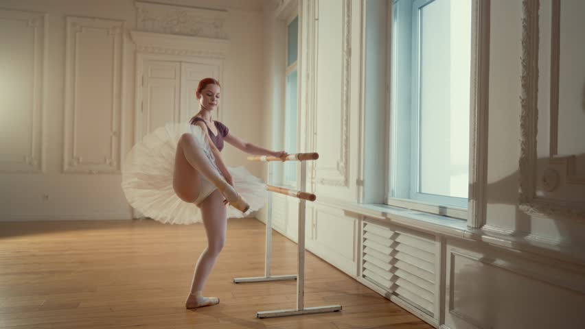 Rehearsing in dance class, graceful ballerina practicing at and stretching legs . Slender young ballet dancer woman exercising alone in dance class, classic music and professional dance performer - Powered by Shutterstock - Get 15% off with code: PIKWIZARD15