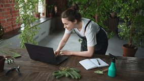 Female florist gardener working in botanical store greenhouse using laptop order plants communicating on Internet with customer. Small business owner working at flower shop. Running of own business - Powered by Shutterstock - Get 15% off with code: PIKWIZARD15