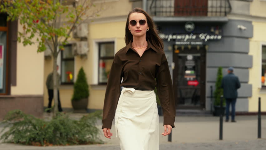 Stylish fashionable elegant confident Caucasian woman businesswoman girl female business model in dark sunglasses walking in city walk outdoors go outdoor going street fashion style luxury lady move