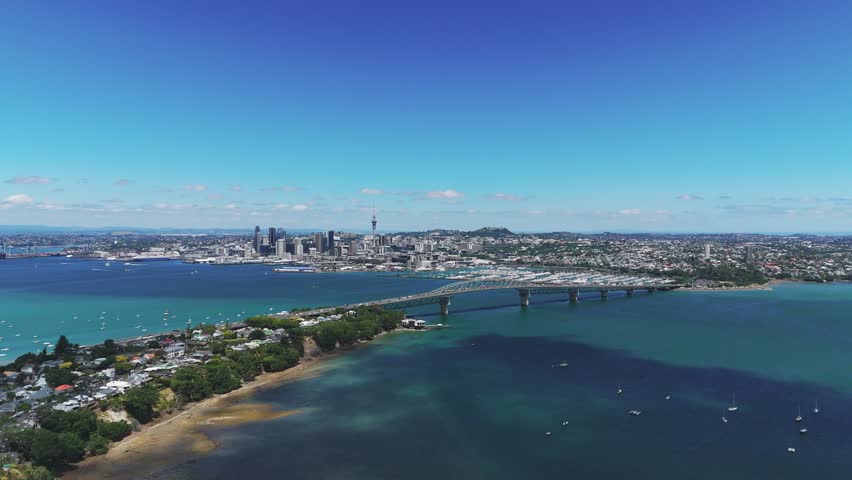 Auckland cityscape with Waitemata Harbour, bridge, and marina under sunny skies