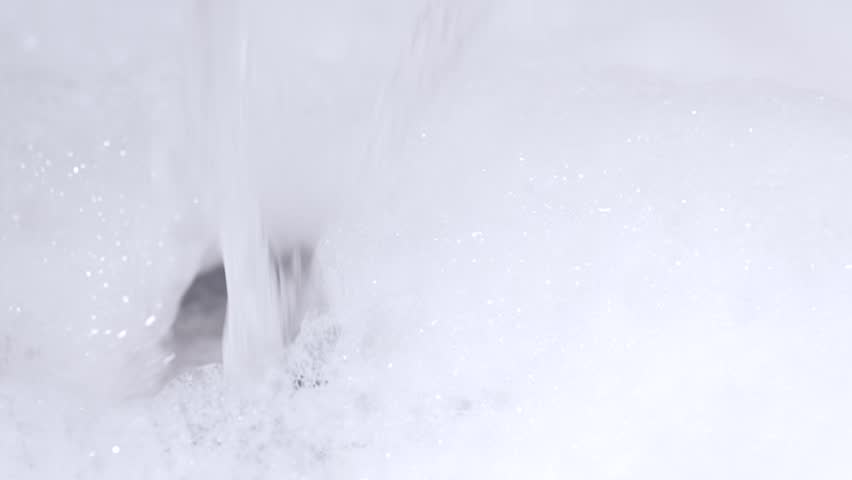 Bathtub with soap suds. Preparing a bath, water pouring in soap suds. Foam with bubbles popping in water.