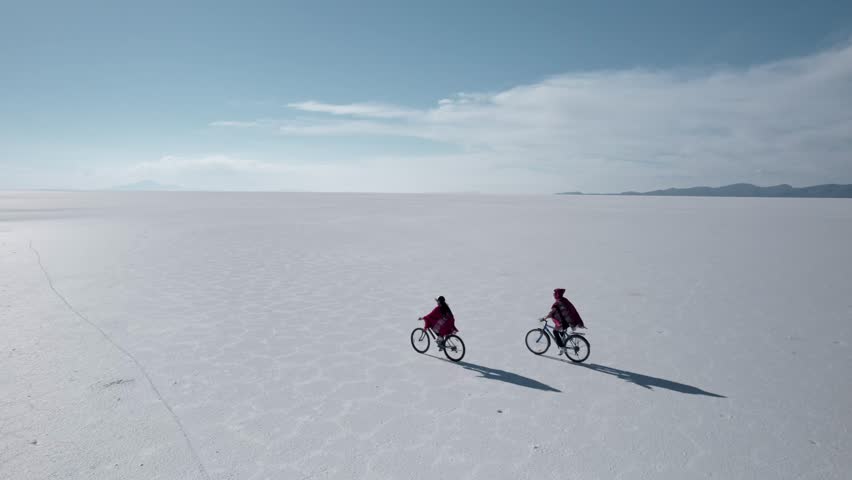 Couple Biking Across a Stunning Landscape in the Salt Flats - Salar de Uyuni, Bolivia