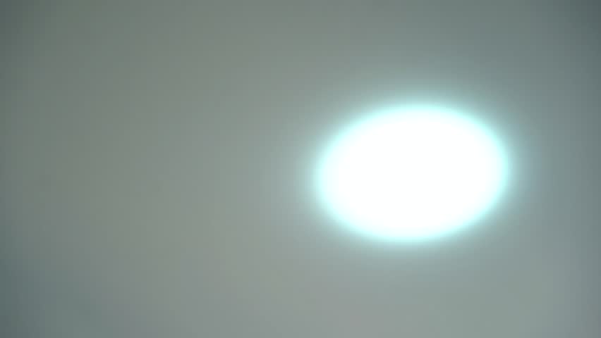Round ceiling lamp in minimalist style turning on and off. White ceiling and white lamp
