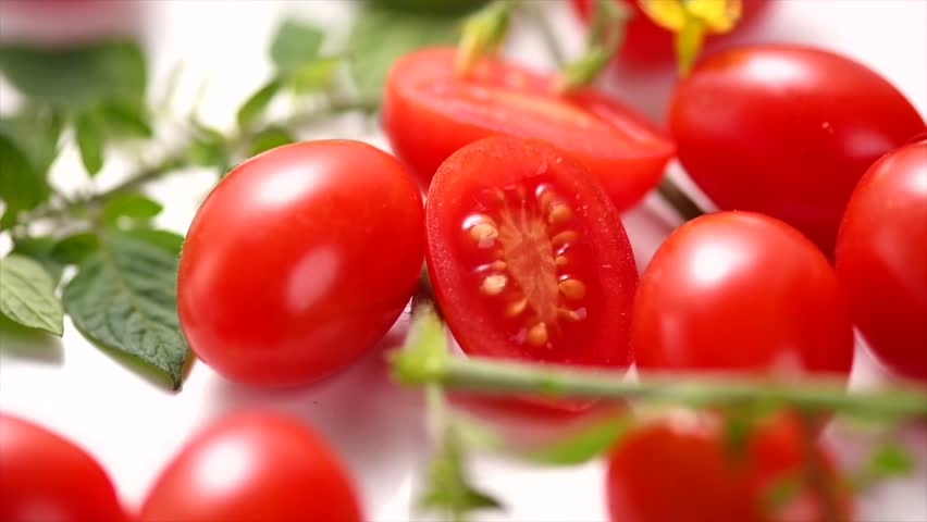 Cherry tomato Fresh Ripe little tomatoes close-up. Organic tomato with leaves rotating on white background. Macro shot. Garden, Gardening concept. Ketchup, pasta, sauce ingredient. 