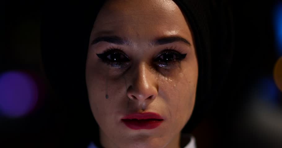 Close-up shot sad crying muslim woman with smudged make up looking Into the camera. Violence theme. Background is night bokeh. 4K 4096x2160