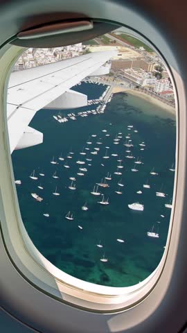 Aerial view of San Antonio Abad, Sant Antoni de Portmany, main tourist center of the island of Ibiza, Spain. Panoramic aerial view,  seen through the airplane window. vertical and portrait format