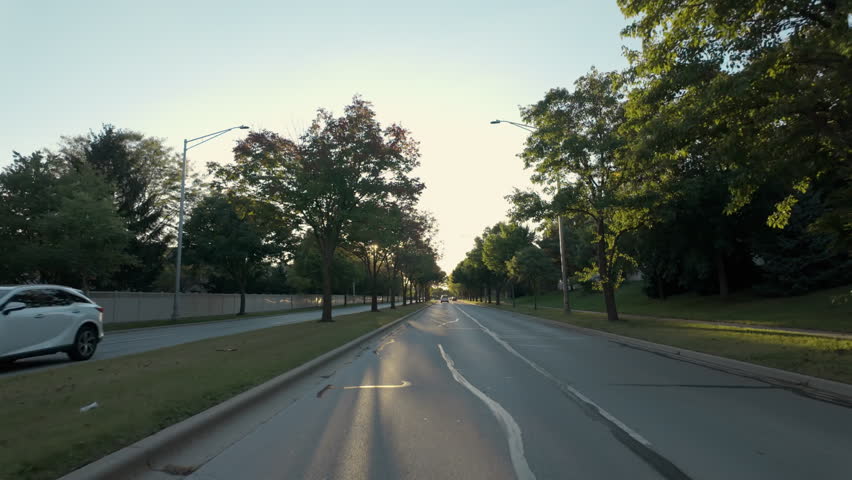 POV shot moving car of suburban street in USA neighborhood on a beautiful sunny day. 