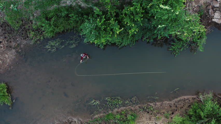 Fisherman casts fly and catches fish on a small river. Set of clips about small river fishing. Male angler casts, strikes, catches fish and shows his best fly.