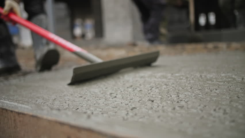Leveling wet concrete with a tool