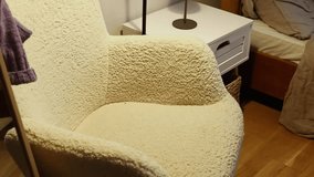 A young woman sits in a cozy armchair under the soft light of a floor lamp and begins reading a book. Close-up shot capturing a calm and relaxing atmosphere, ideal for concepts of comfort, leisure, an - Powered by Shutterstock - Get 15% off with code: PIKWIZARD15