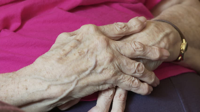 Elderly woman's hands, deformed by arthritis.
