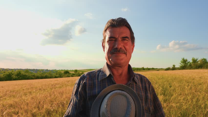 senior male brazilian farmer takes his hat off and looking at camera. the portrait of an elderly man working in the head at sunset,
