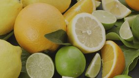 Ripe citrus fruits with slices and citrus leaves slowly move in the frame on a gray stone table. Macro video shooting. - Powered by Shutterstock - Get 15% off with code: PIKWIZARD15