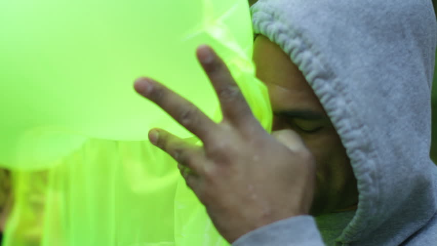 Close up of a man inflating a bright green airbed.