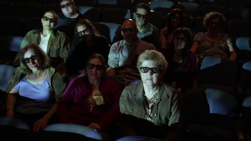 Audience reaction at 3D movie screening. Camera moves on a jib and moving images