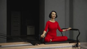 Woman performing Pilates mermaid exercise on reformer - Powered by Shutterstock - Get 15% off with code: PIKWIZARD15