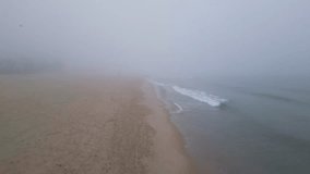 A foggy beach with soft sand and gentle waves meeting the shoreline. Footprints trail along the coast, blending into the misty atmosphere. Calm water and muted tones create a peaceful, tranquil scene - Powered by Shutterstock - Get 15% off with code: PIKWIZARD15