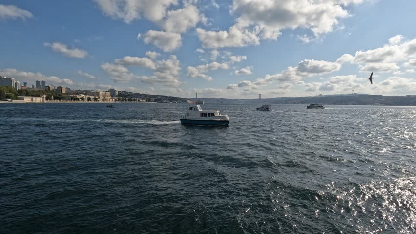 A sea taxi navigates the Marmara under a blue sky, with Dolmabahçe Palace, the Bosphorus Bridge, and the waterway blending historic landmarks and maritime activity in this iconic Istanbul scene