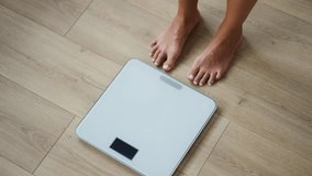 Video of of healthy young woman, happy to see that she has lost weight on scale weight at home - Powered by Shutterstock - Get 15% off with code: PIKWIZARD15