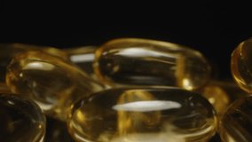 Dolly Slider Close Up of Golden Transparent Omega 3 Capsules Highlighting Their Smooth Glossy Texture and Reflections on a Dark Background Nutritional Supplementation - Powered by Shutterstock - Get 15% off with code: PIKWIZARD15