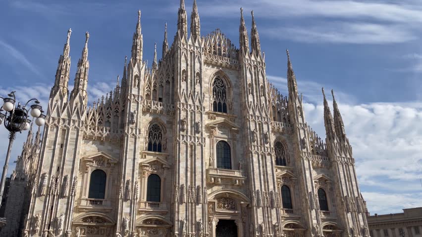 The Duomo of Milan Cathedral facade on sunny day. Italian landmark in Town Square. Catholic religion, travel destination concepts
