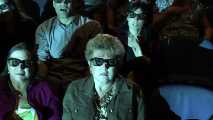 Audience jumps back at a dramatic event during a 3D movie screening. Camera