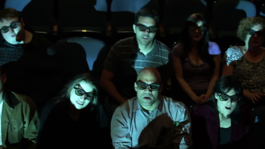 Audience reacts to a creepy 3D movie screening. Camera moves on a jib and moving