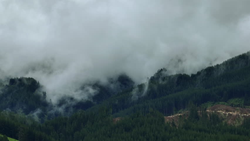 Drone Shot of Rain Clouds Moving Over Heavily Forested Mountain Range, New Zealand