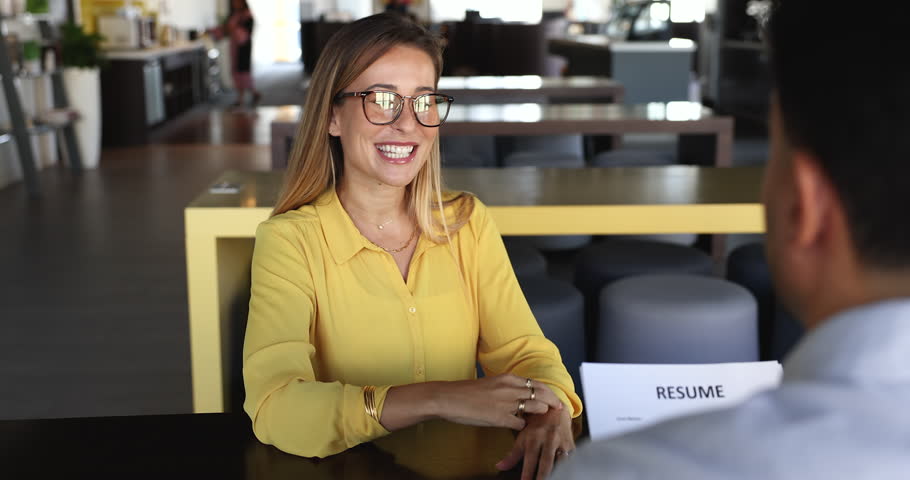 Female vacancy position applicant passing job interview sit in front of HR manager holding resume listening candidature speaking about competence, professionalism and education. Hiring, recruitment