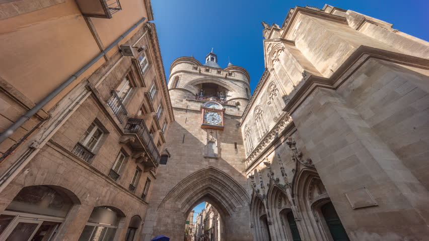 Porte Saint Eloi timelapse hyperlapse, also called Grosse Cloche, is a medieval gothic gate in Bordeaux, France. A symbol of the city's history with a big bell and clock. Blue sky enhances its beauty