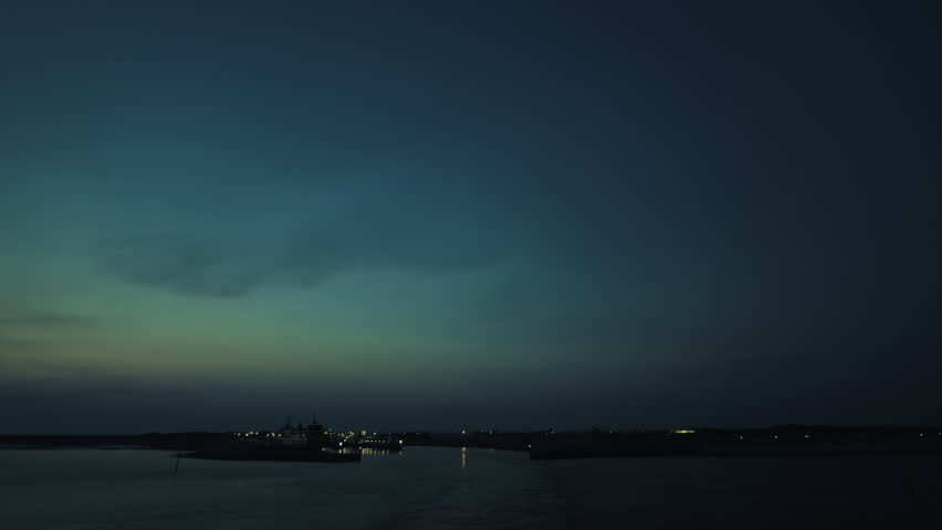 Quiet view of Texel harbor at dusk, showcasing the fading twilight sky, subtle reflections on the water, and distant harbor lights.