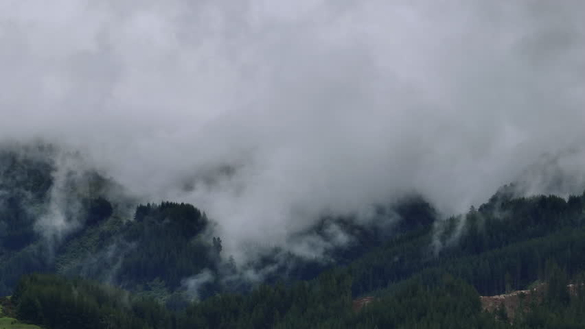 Drone Shot of Rain Clouds Moving Over Heavily Forested Mountain Range, New Zealand
