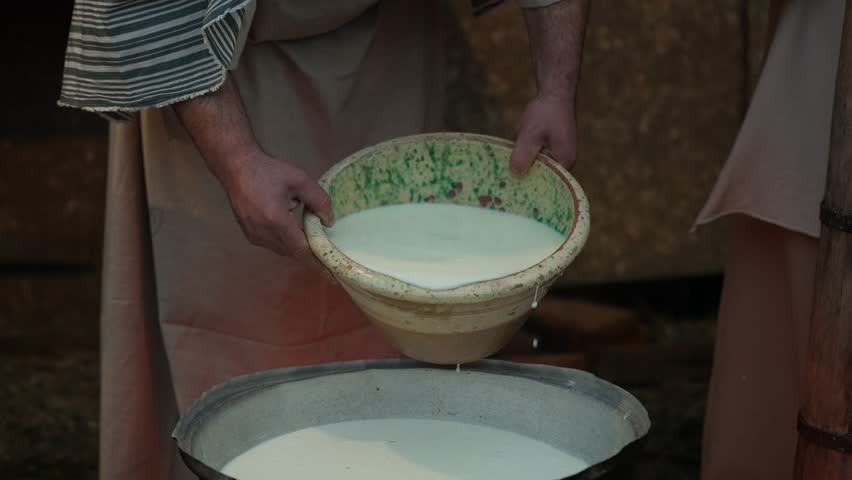 White Milk Poured into Cauldron Boiling for Handmade Cheese Production in Village Dairy
