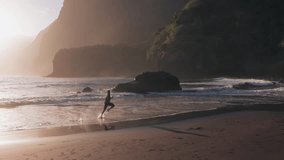 Aerial view of active young man running fast on black sand volcanic beach with crashing waves. Male in vacation  exercising on a beach in Seixal Madeira on a beautiful morning  - Powered by Shutterstock - Get 15% off with code: PIKWIZARD15