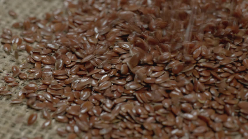 flax seeds falling on white surface and bouncing , 4k , stable shot