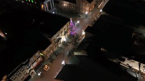 Small city in Midwest lighting in Christmas colors at night. Illuminated Christmas tree in center of town. Aerial top down shot. - Powered by Shutterstock - Get 15% off with code: PIKWIZARD15