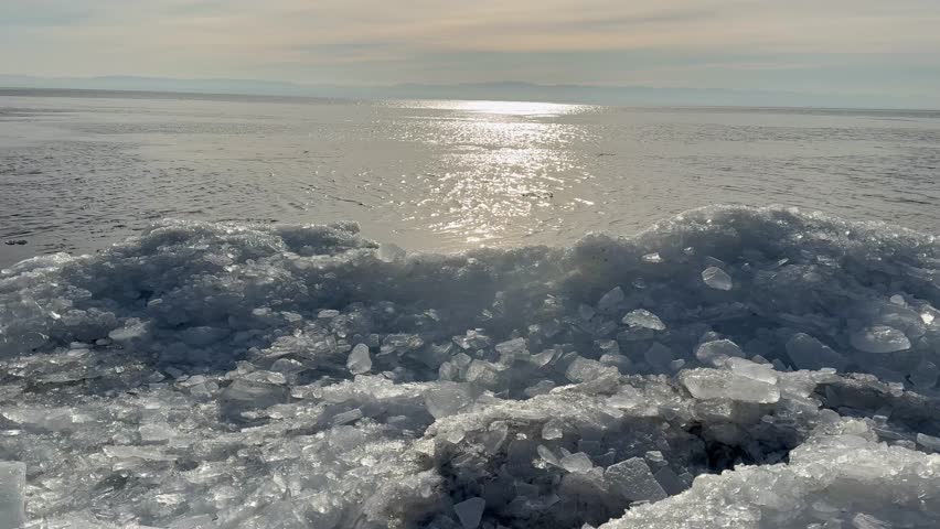 Video of Baikal Lake in January morning during freeze-up. Icy beach on frosty calm sunrise. Scenic sea landscape. Natural background. Winter travels and outdoors