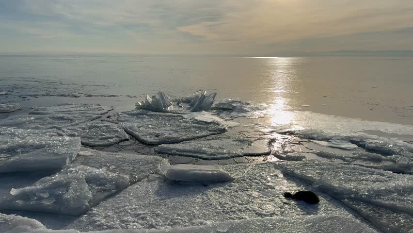 Video of Baikal Lake in January morning during freeze-up. Icy beach on frosty calm sunrise. Scenic Baikal landscape. Natural background. Change seasons, environment. Winter travels and outdoors