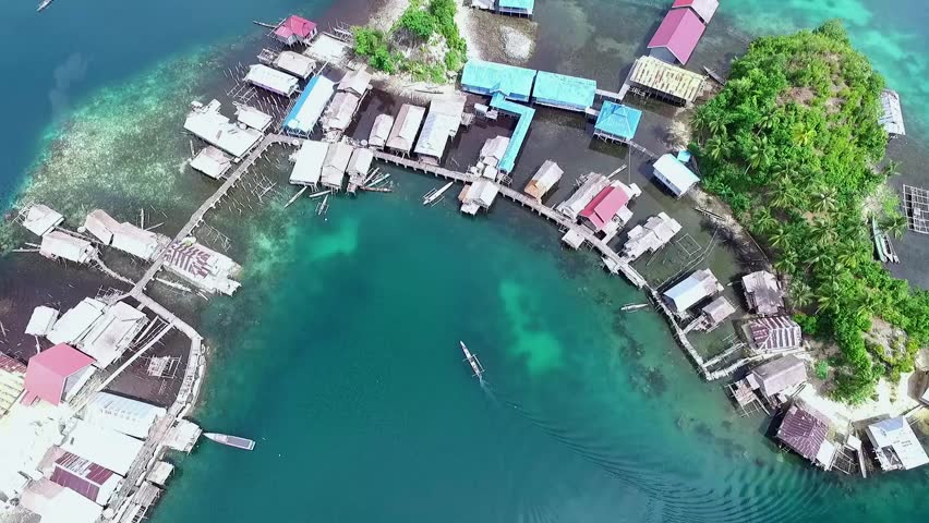 Togean islands, central sulawesi, Indonesia - September 2017: beautyful aerial view of sea gypsy houses "bajau trible village". natural blue water, white sand and coral reefs surround their homes