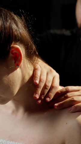 Professional physiotherapist performing neck and shoulder massage, releasing muscular tension through targeted manual therapy techniques in controlled, precise movements