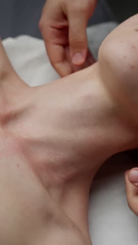 Skilled massage therapist performing therapeutic neck massage, alleviating muscle tension and supporting holistic wellness through precise, calming bodywork technique